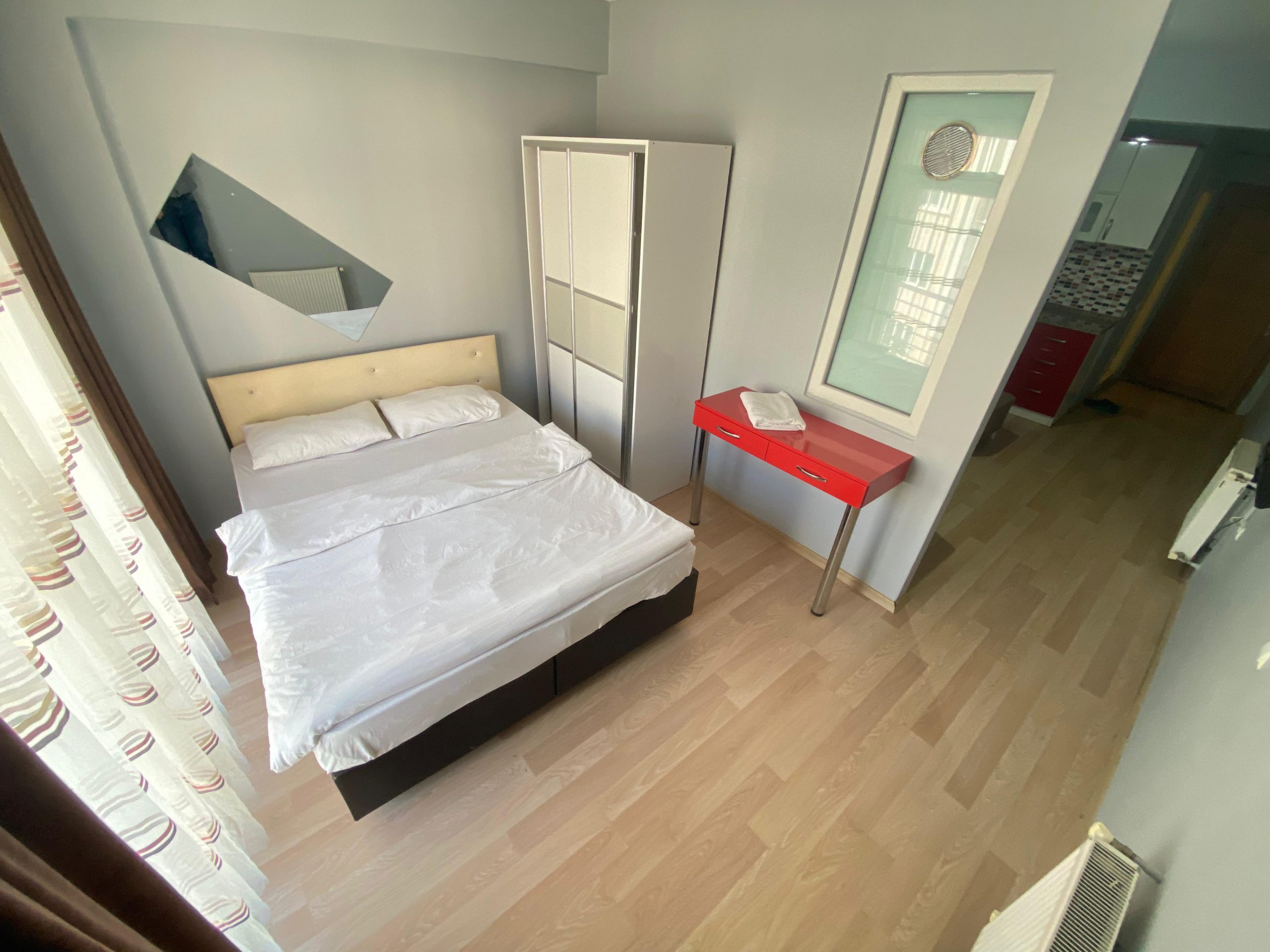Eskişehir Alesta Apart’ın modern dizayn edilmiş bir odası; yatak, masa ve sandalye ile donatılmış.