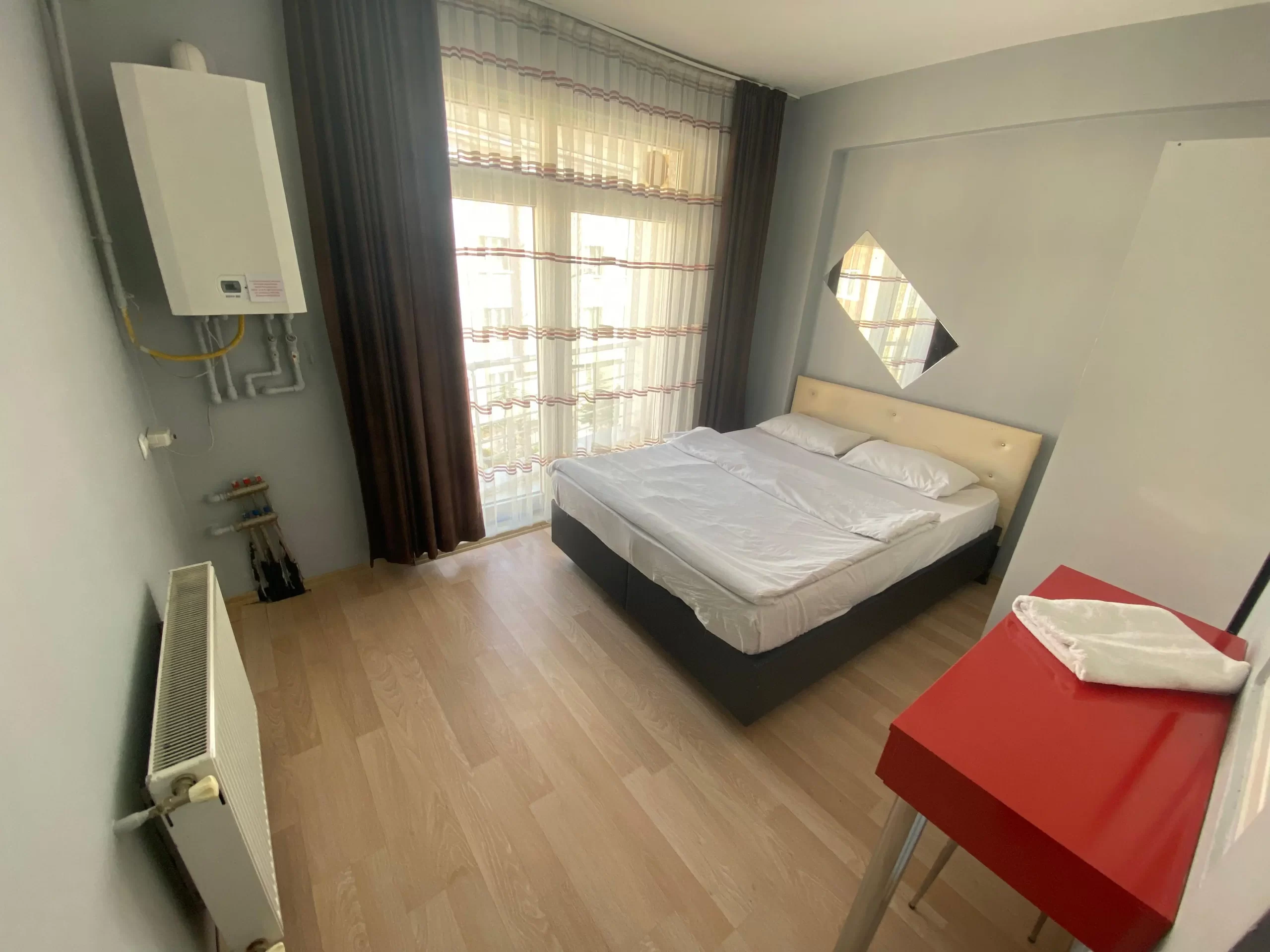Eskişehir Alesta Apart’ın modern dizayn edilmiş bir odası; yatak, masa ve sandalye ile donatılmış.